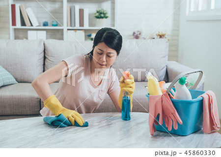 asian housewife wiping hard on marble table asian housewife wiping hard on marble table 45860330