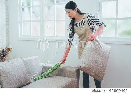 wife using feather duster cleaning the couch wife using feather duster cleaning the couch 45860492