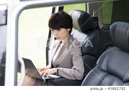 車の後部座席で仕事をするキャリアウーマン 45862782