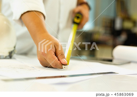 Architecture hand measuring blueprint with tape masure on working table. 45863069