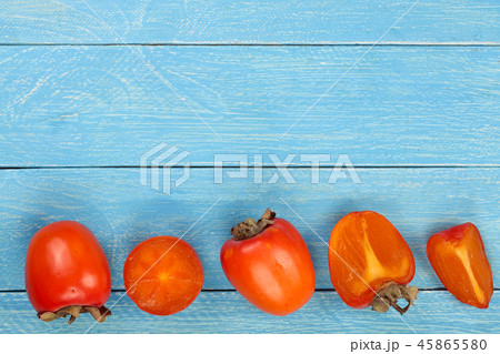 persimmon on blue wooden background with copy space for your text. Top view. Flat lay pattern 45865580