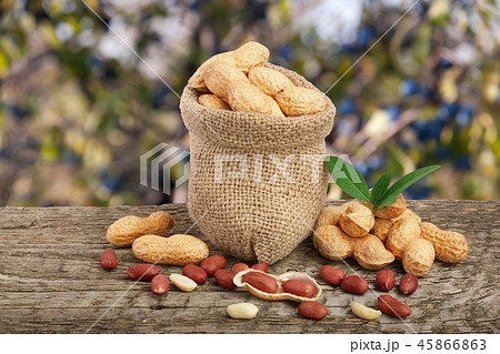 peanuts with leaf in bag on old wooden table with a blurry garden background peanuts with leaf in bag on old wooden table with a blurry garden background 45866863