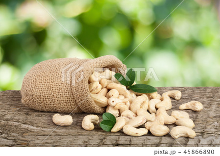 cashew nuts with leaf in bag on a wooden table with blurred garden background 45866890