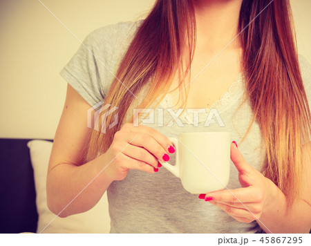 Woman holding cup of hot drink, no face 45867295