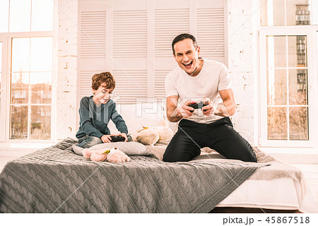 Father and son immersed in playing an interesting game. Father and son immersed in playing an interesting game. 45867518