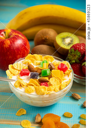 Tasty cornflakes with milk and fruits in glass bowl 45869123