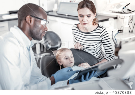 Concentrated female person sitting near her daughter Concentrated female person sitting near her daughter 45870388