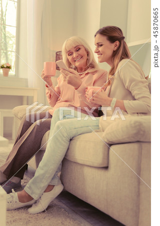 Positive aged woman holding her new smartphone Positive aged woman holding her new smartphone 45870665