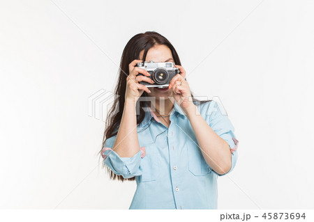 Happy european female model with dark hair enjoying indoor photoshoot. Young woman is taking a photo 45873694