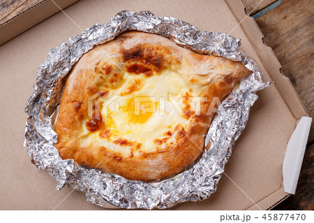 Adjarian open khachapuri with egg on wooden board 45877470