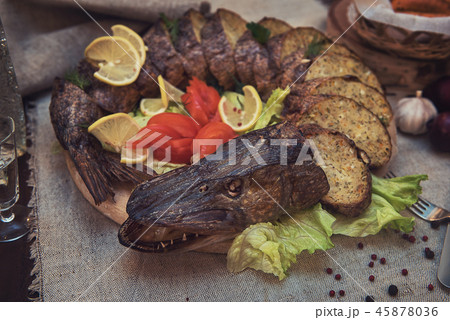 Stuffed pike with vegetables and greens. 45878036