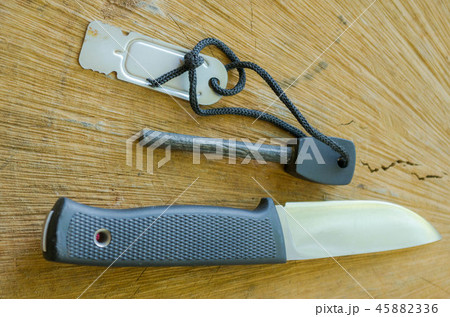 Tourist knife with flint. Knife and flint on wood Tourist knife with flint. Knife and flint on wood 45882336