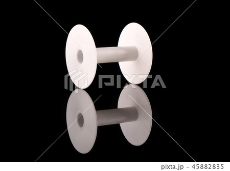 White plastic empty reel on a black background with reflection 45882835