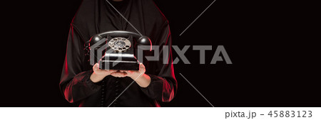 Portrait of beautiful serious scared young muslim woman wearing black hijab offering telephone to Portrait of beautiful serious scared young muslim woman wearing black hijab offering telephone to 45883123