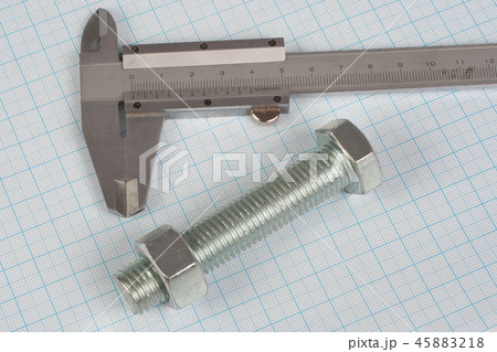 Screw, Nuts and caliper on graph paper background 45883218
