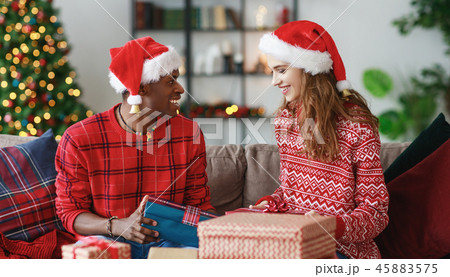 happy couple opening presents on Christmas morning happy couple opening presents on Christmas morning 45883575