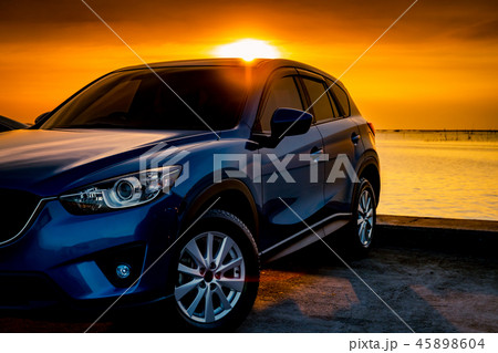 Front view blue SUV car parked by sea at sunset. 45898604