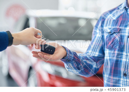 Crop of hands when one person giving car's key to another. Crop of hands when one person giving car's key to another. 45901373