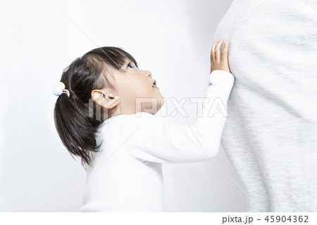 妊娠したお母さんの大きなお腹を触り見上げる幼い女の子。妊娠,妊婦,親子,家族,愛,幸せイメージ 45904362