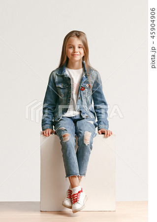 Full length portrait of cute little teen in stylish jeans clothes looking at camera and smiling Full length portrait of cute little teen in stylish jeans clothes looking at camera and smiling 45904906