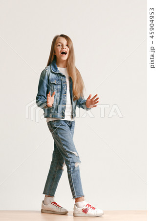 Full length portrait of cute little teen in stylish jeans clothes looking at camera and smiling 45904953