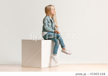 The portrait of cute little kid in stylish jeans clothes looking at camera and smiling 45905108