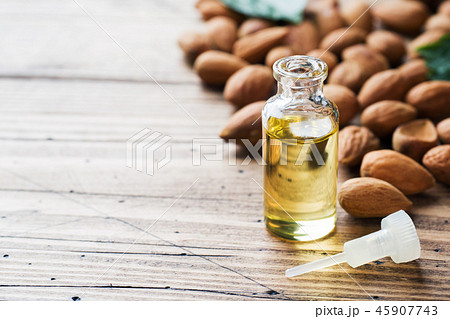 Almond oil in bottle on wooden background.  45907743