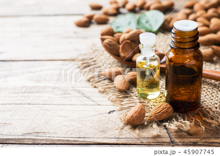 Almond oil in bottle on wooden background.  45907745