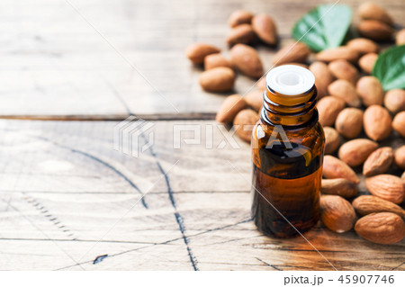 Almond oil in bottle on wooden background. Almond oil in bottle on wooden background. 45907746