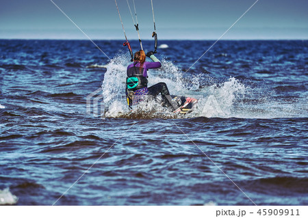 A female kiter slides on the surface of the water 45909911
