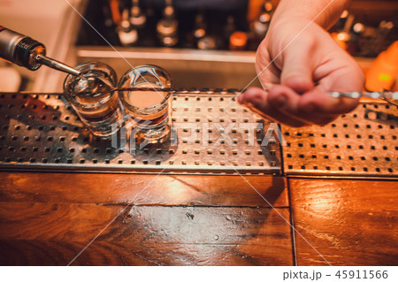 Bartender making shots on black bar with reflection. Bartender making shots on black bar with reflection. 45911566