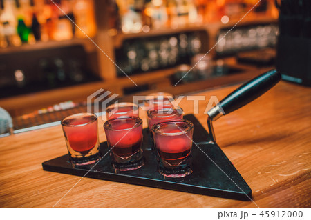 Bartender is pouring tequila into glass against the background of the bar. 45912000