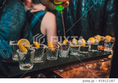Tequila shot with lime and sea salt on black table, selective focus 45912187