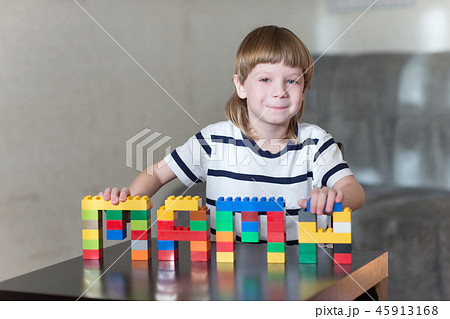 boy playing with lots of colorful plastic blocks indoor boy playing with lots of colorful plastic blocks indoor 45913168