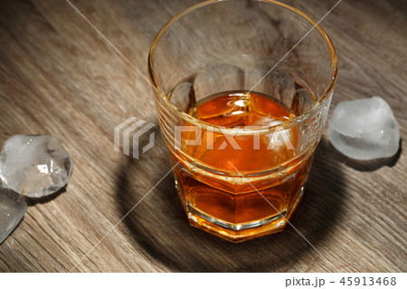 Glass of alcoholic drink with ice cubes  45913468