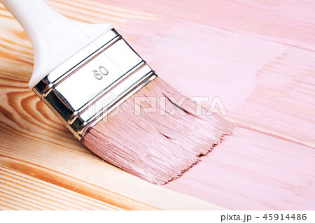 Close up of white paint brush painting wooden board. 45914486