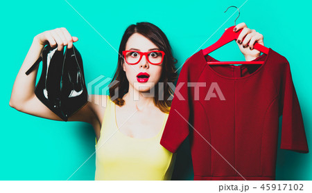 young woman with dress on hanger and shoes 45917102