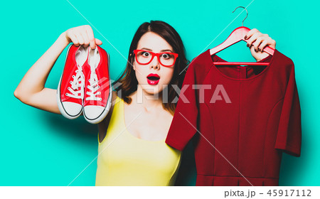 young woman with dress on hanger and gumshoes 45917112