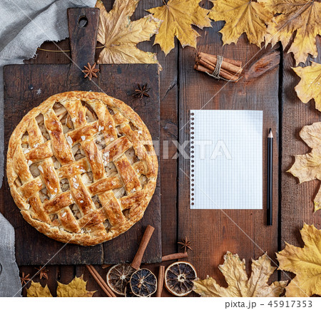whole round apple pie on a brown wooden board 45917353