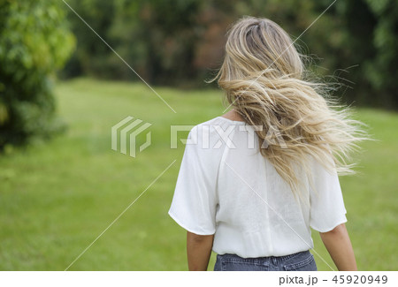 Rear view of young woman with windswept hair Rear view of young woman with windswept hair 45920949
