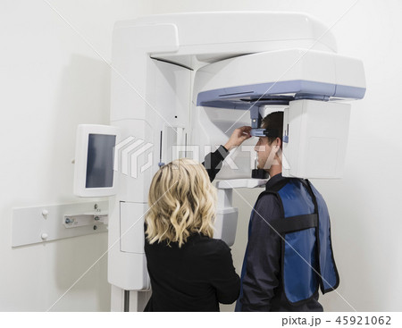 Dental nurse adjusting x-ray machine for patient Dental nurse adjusting x-ray machine for patient 45921062