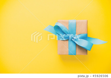 gift wrapped and decorated with blue bow on yellow gift wrapped and decorated with blue bow on yellow 45926506