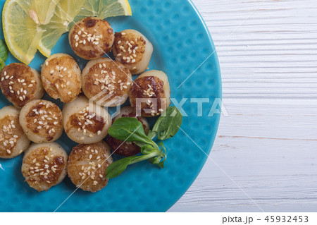 Fried scallops with lemon and salad Fried scallops with lemon and salad 45932453