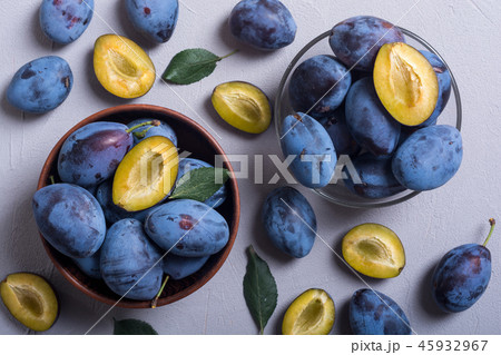Fresh plums in bowl on wooden table 45932967