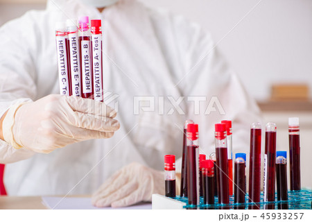 Young handsome lab assistant testing blood samples in hospital  45933257