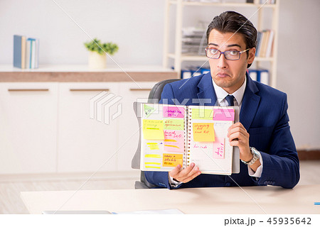 Young handsome employee planning his work activity Young handsome employee planning his work activity 45935642