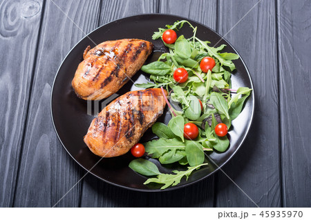 Grilled chicken with spinath and tomatoes salad Grilled chicken with spinath and tomatoes salad 45935970