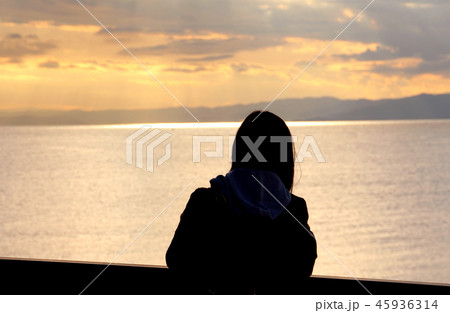 夕暮れの海岸と女性 45936314
