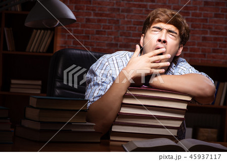 Young handsome student preparing for exams at night Young handsome student preparing for exams at night 45937117