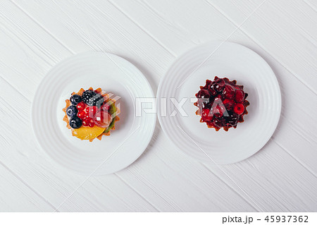 Cakes with berries on white table, top view Cakes with berries on white table, top view 45937362